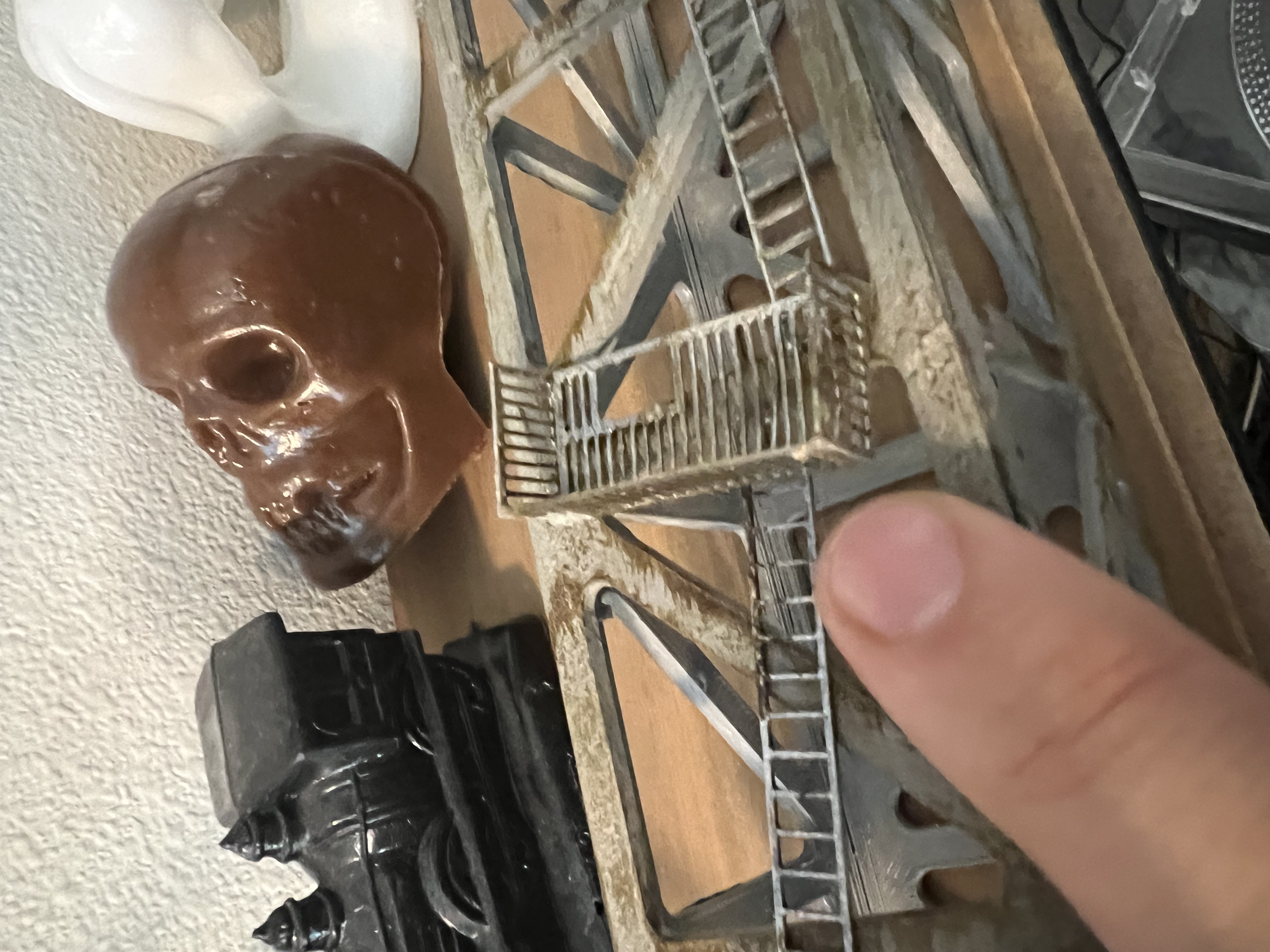 The tiny ladder and fire escape crudely arranged against the girder, with mold-a-rama figures visible behind.