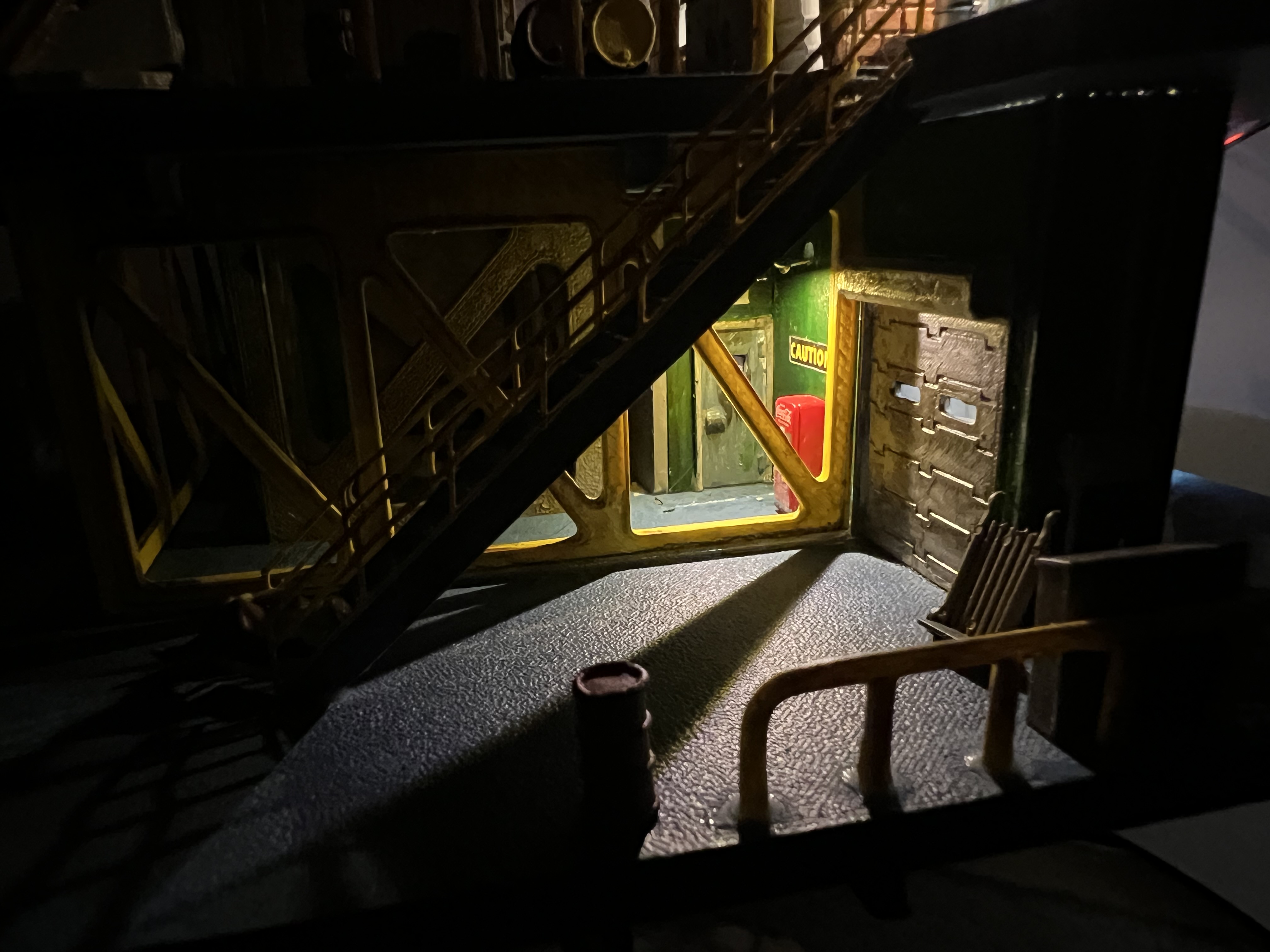 The lower deck of the drinkrig at night, lit from within.