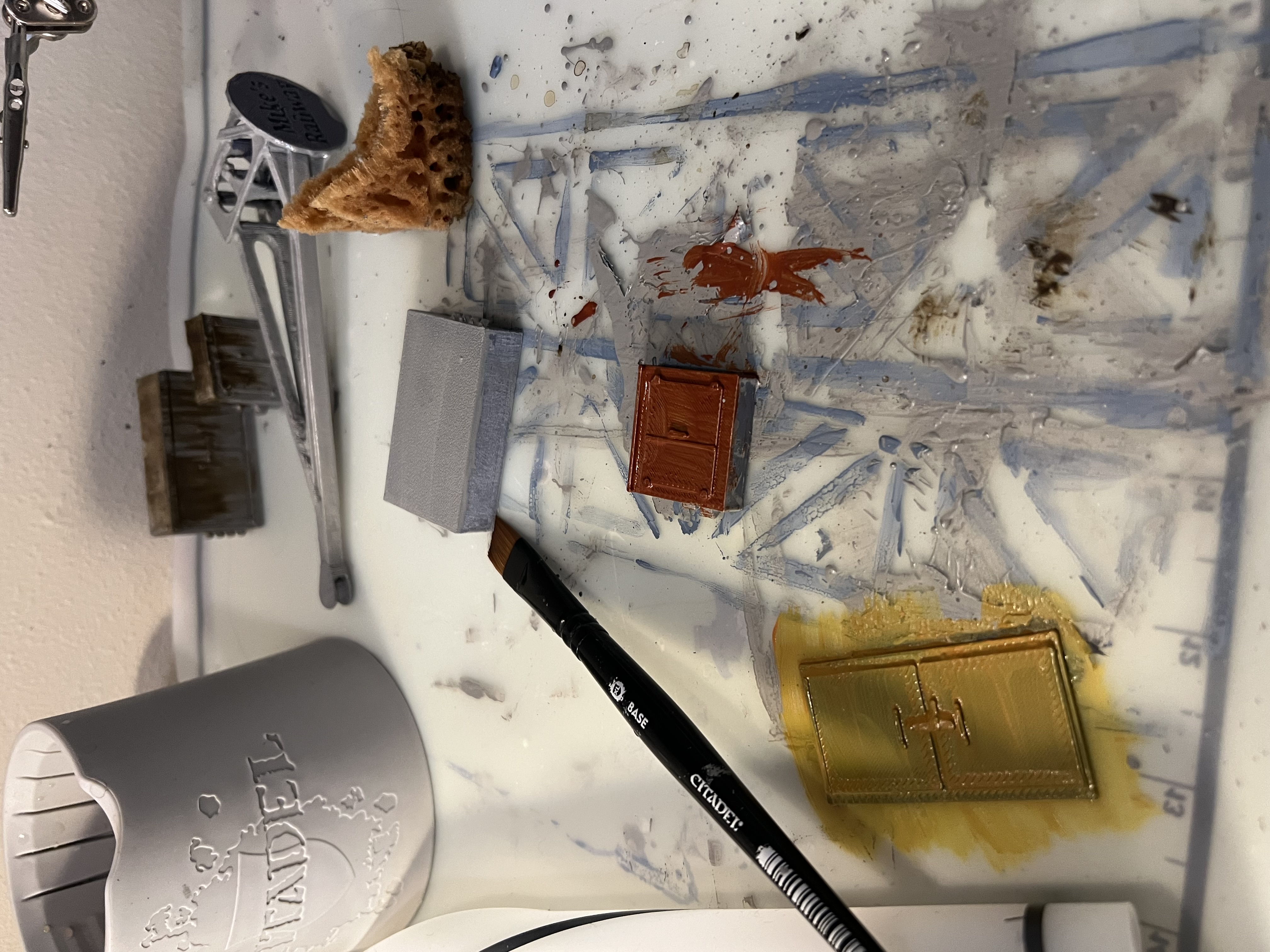Several test pieces painted in different bright colors over a gray base, all reading as muddy.